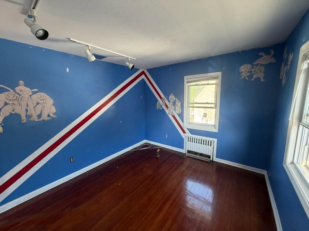 Blue bedroom with a chevron stripe wrapping the corner and character decals before repainting