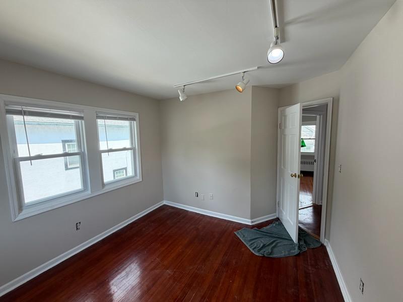 The same bedroom repainted in warm greige with fresh white trim and ceiling